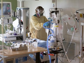 A nurse tends to a patient in the COVID-19 intensive care unit at Surrey Memorial Hospital.