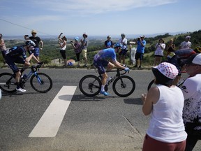 Matteo Jorgenson of the U.S., left, and Canada's Hugo Houle, center, ride in the breakaway during the thirteenth stage of the Tour de France cycling race over 193 kilometers (119.9 miles) with start in Le Bourg d'Oisans and finish in Saint-Etienne, France, Friday, July 15, 2022.