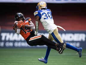B.C. Lions' Dominique Rhymes, left, makes a reception as Winnipeg Blue Bombers' Winston Rose defends during the first half of CFL football game in Vancouver, on Saturday, July 9, 2022.