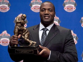 B.C. Lions offensive tackle Jovan Olafioye holds the trophy for Most Outstanding Offensive lineman trophy as he poses for photographers during the CFL awards show in Toronto, Thursday, November 22, 2012 The names of kicker Paul McCallum and Olafioye are being added to the B.C. Lions' Wall of Fame.