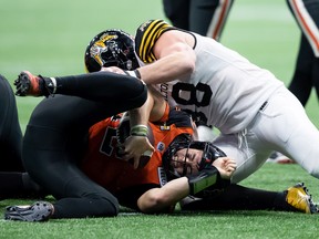 B.C. Lions quarterback Nathan Rourke, front left, is sacked by Hamilton Tiger-Cats' Dylan Wynn during the second half of CFL football game in Vancouver, on Thursday, July 21, 2022.