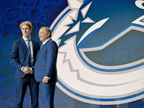 Jonathan Lekkerimaki shakes hands with NHL commissioner Gary Bettman after being selected as the number fifteen overall pick to the Vancouver Canucks in the first round of the 2022 NHL Draft at Bell Centre.
