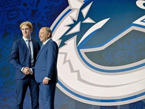 Jonathan Lekkerimaki shakes hands with NHL Commissioner Gary Bettman after being selected as the Vancouver Canucks' fifteenth overall pick in the first round of the 2022 NHL Draft at Bell Centre.