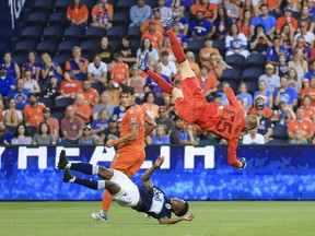 Vancouver Whitecaps goalkeeper Cody Cropper (55) flips in the air as he collides with defender Javain Brown (bottom) in the game against FC Cincinnati in the first half at TQL Stadium.