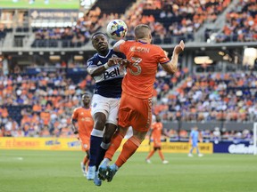 Vancouver Whitecaps forward Cristian Dajome (left) heads the ball against FC Cincinnati defender John Nelson (3) in the first half at TQL Stadium.