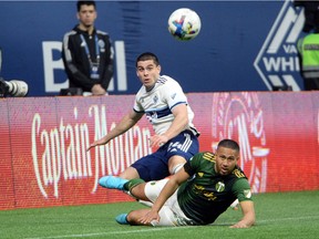 Vancouver Whitecaps forward Brian White (24) and Portland Timbers defender Bill Tuiloma (25) battle for the ball during the second half at BC Place. White scored the Caps' lone goal on Sunday night in a 1-1 draw against the Timbers in Portland.