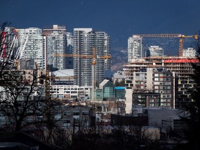 Construction cranes tower above condos near southeast False Creek in Vancouver.
