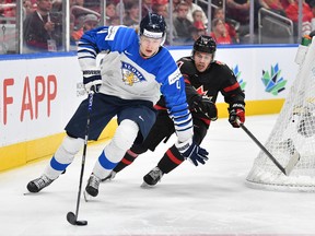 Logan Stankoven #10 of Canada battles for the puck against Joni Jurmo #4 of Finland in the IIHF World Junior Championship on August 20, 2022 at Rogers Place in Edmonton, Alberta, Canada