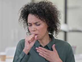 Portrait of Sick Young African Woman Coughing getty