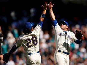 Eugenio Suarez #28 and Ty France #23 of the Seattle Mariners celebrate a 4-0 win against the Cleveland Guardians at T-Mobile Park on August 28, 2022 in Seattle, Washington.