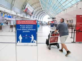 A man pushes a baggage cart wearing a mandatory face mask as a "Healthy Airport" initiative is launched for travel, taking into account social distancing protocols to slow the spread of the coronavirus disease (COVID-19) at Toronto Pearson International Airport in Toronto, Ontario, Canada June 23, 2020.