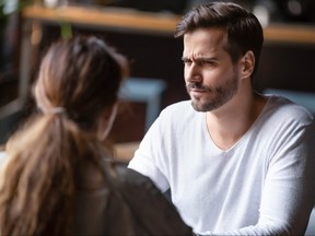 Doubting dissatisfied man looking at woman on bad date.