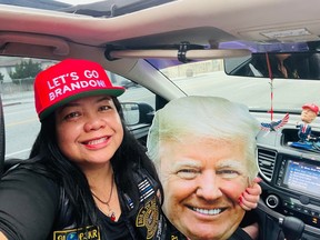 Trump-loving Mimi Israelah holding up sign of Donald Trumps face.