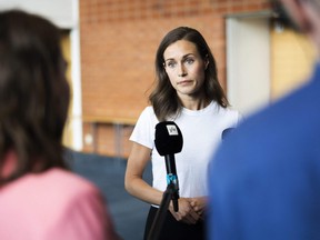 Prime Minister of Finland Sanna Marin (C) answers journalists' questions on August 18, 2022 in Kuopio, Finland before the start of the Social Democratic Party's parliamentary group summer meeting. (Photo by Matias HONKAMAA / LEHTIKUVA
