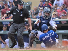 Toronto Blue Jays second baseman Whit Merrifield (1) is initially called out by umpire Marty Foster (60) at the plate on a tag by Minnesota Twins catcher Gary Sanchez (24) during the tenth inning at Target Field. Merrifield scored on a sacrifice fly by first baseman Cavan Biggio (not pictured) to left fielder Tim Beckham (not pictured). The call was challenged by the Twins and overturned, ruling Merrifield safe on the play due to the catcher blocking the plate.
