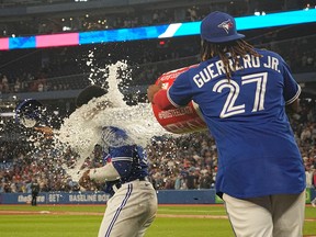 Toronto Blue Jays first baseman Vladimir Guerrero Jr. (27) throws a bucket of water onto right fielder Teoscar Hernandez (37) after defeating the Chicago Cubs at Rogers Centre. Mandatory Credit: John E. Sokolowski-USA TODAY Sports
