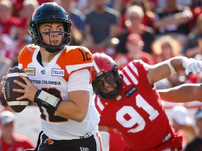 B.C. Lions quarterback Nathan Rourke takes off with the ball under pressure from Isaac Adeyemi-Berglund of the Calgary Stampeders during Saturday’s CFL game in Calgary.