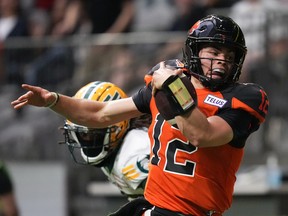 B.C. Lions quarterback Nathan Rourke (12) is pushed out of bounds by Edmonton Elks' Jalen Collins as he runs with the ball during the first half of CFL football game in Vancouver, on Saturday, June 11, 2022.