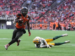 B.C. Lions’ James Butler, left, gets away from a tackle by Edmonton Elks’ Trey Hoskins and runs the ball in for his first touchdown during the first half of CFL football game in Vancouver, on Saturday, June 11, 2022.