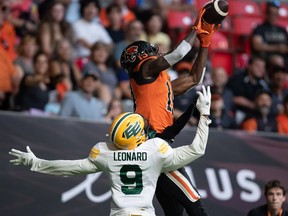 BC Lions' Dominique Rhymes, back, makes a touchdown reception in the end zone as Edmonton Elks' Raphael Leonard defends during the first half of CFL football game in Vancouver, on Saturday, Aug. 6, 2022.
