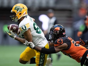 Edmonton Elks' Kenny Lawler, left, fumbles the ball on a kick return and turns it over as BC Lions' Delvin Breaux Sr. tackles him during the first half of the CFL football game in Vancouver, on Saturday, Aug. 6, 2022.