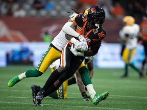BC Lions' Jevon Cottoy (86) is tackled by Edmonton Elks' Treston Decoud after making the reception during the first half of CFL football game in Vancouver, on Saturday, Aug.  6, 2022.
