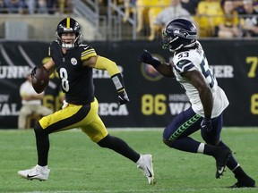 Aug 13, 2022; Pittsburgh, Pennsylvania, USA;  Pittsburgh Steelers quarterback Kenny Pickett (8) scrambles with the ball as Seattle Seahawks linebacker Boye Mafe (53) chases during the fourth quarter at Acrisure Stadium. The Steelers won 32-25.