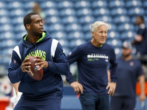 Aug 18, 2022; Seattle, Washington, USA; Seattle Seahawks quarterback Geno Smith (7) participates in early pregame warmups against the Chicago Bears while head coach Pete Carroll (background) watches at Lumen Field. Mandatory Credit: Joe Nicholson-USA TODAY Sports
