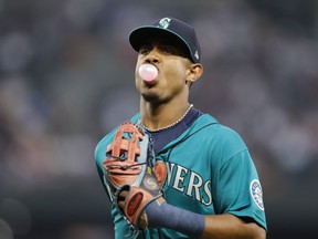 Seattle Mariners' Julio Rodriguez blows a bubble as he runs to the dugout while leaving the field during the second inning of a baseball game against the Cleveland Guardians, Friday, Aug. 26, 2022, in Seattle.