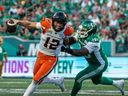BC Lions quarterback Nathan Rourke escapes a tackle from Saskatchewan Roughriders defensive lineman Charleston Hughes during their Canadian Football League game July 29, 2022 in Regina.
