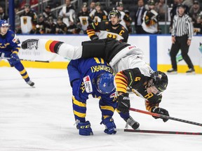 Germany’s Maksymilian Szuber (4) goes over top of Sweden’s Jonathan Lekkerimaki (24) during third period IIHF World Junior Hockey Championship action in Edmonton on Monday Aug. 15, 2022.