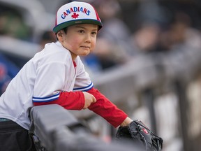 A young fan looks to catch a foul ball in the left field stands during an exhibition game between the University of British Columbia Thunderbirds and the Vancouver Canadians at Nat Bailey Stadium Vancouver, BC, April, 06, 2022.
