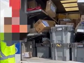 An image taken from a video that shows an apparent Canada Post worker hurling boxes into the back of his truck