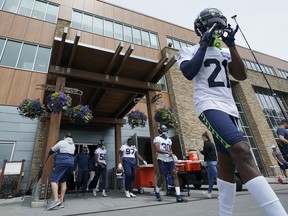 Seattle Seahawks cornerback Artie Burns, right, walks out of the Seahawks' headquarters building for NFL football practice on June 8, 2022, in Renton, Wash.