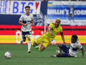 Nashville FC's Hany Mukhtar, front left, is upended by Vancouver Whitecaps' Javain Brown during first half MLS soccer action in Vancouver on Saturday, August 27, 2022.