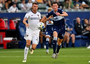 August 13, 2022; Carson, California, USA. Los Angeles Galaxy forward Nick DePuy (20) and Vancouver Whitecaps midfielder Easton Ongaro (43) battle for the ball in the first half at Dignity Health Sports Park.