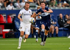 Aug 13, 2022; Carson, California, USA; Los Angeles Galaxy forward Nick DePuy (20) and Vancouver Whitecaps midfielder Easton Ongaro (43) battle for the ball in the first half at Dignity Health Sports Park.