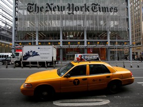 A taxi passes by in front of The New York Times head office in New York, February 7, 2013. REUTERS/Carlo Allegri