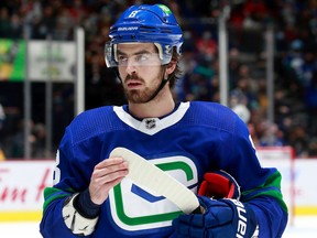 Conor Garland looks on from the bench during their NHL game against the Chicago Blackhawks at Rogers Arena Nov. 21, 2021 in Vancouver.