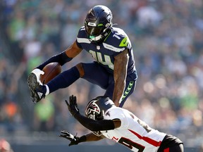 DK Metcalf #14 of the Seattle Seahawks jumps over Casey Hayward #29 of the Atlanta Falcons during the second quarter at Lumen Field on September 25, 2022 in Seattle, Washington.