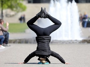 A woman makes a headstand in the Lustgarten park on Museum Island in central Berlin.