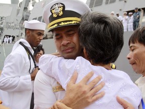 In this photo taken Dec. 3, 2010, U.S. navy officer Michael "Vannak Khem" Misiewicz becomes emotional as he embraces his aunt Samrith Sokha, 72, at Cambodian coastal international see port of Sihanoukville, Cambodia. Misiewicz passed confidential information on ship routes to Malaysian businessman Leonard Francis' Singapore-based company, Glenn Defense Marine Asia Ltd., or GDMA, according to the court documents. Misiewicz and Francis moved Navy vessels like chess pieces, diverting aircraft carriers, destroyers and other ships to Asian ports with lax oversight where Francis could inflate costs, according to the criminal complaint. The firm overcharged the Navy millions for fuel, food and other services it provided, and invented tariffs by using phony port authorities, the prosecution alleges.