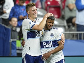 Vancouver Whitecaps midfielder Julian Gressel (19) celebrates with teammate Pedro Vite (45) after scoring a goal against the Seattle Sounders in the first half at BC Place.