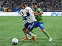 Vancouver Whitecaps midfielder Andres Cubas (20) tries to fight off the challenge of Seattle Sounders midfielder Nicolas Lodeiro (10) in the first half at BC Place.
Cubas left the game midway through the game with an adductor injury. 