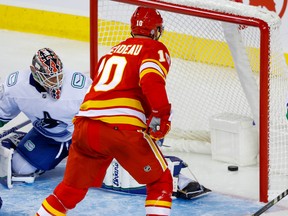 Calgary Flames Jonathan Huberdeau with a goal on Collin Delia of the Vancouver Canucks during preseason NHL hockey in Calgary on Sunday, September 25, 2022.