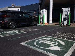An electric car owner prepares to charge his car at an electric car charging station on Sept. 23, 2020 in Corte Madera, Calif.