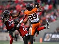 B.C. Lions wide receiver Josh Pearson (89) catches the ball as Ottawa Redblacks defensive back Randall Evans (2) and linebacker Frankie Griffin (28) reach for it during CFL action in Ottawa on June 30.