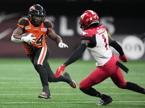 Lions running back James Butler tries to evade Calgary’s Elie Bouka during Saturday’s CFL game at B.C. Place Stadium.
