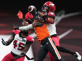 Lions receiver Lucky Whitehead fails to make the catch as Calgary’s Javien Elliott (right) and Trumaine Washington defend during Saturday’s 25-11 Stampeders win at B.C. Place Stadium.