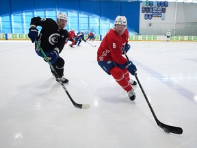Vancouver Canucks’ Brock Boeser, right, tries to keep the puck away from Oliver Ekman-Larsson training camp in Whistler on Thursday, Sept. 22, 2022.